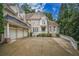 Gorgeous brick home boasting a three-car garage, a grand entrance, and lush greenery at 8630 Moor Park Run, Duluth, GA 30097