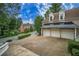 Brick home featuring a three car garage and a large driveway at 8630 Moor Park Run, Duluth, GA 30097