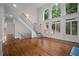 Grand foyer featuring a staircase, hardwood floors, and large windows providing ample natural light at 8630 Moor Park Run, Duluth, GA 30097