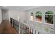 Hallway with views of the backyard through arched windows and a staircase with white railings at 8630 Moor Park Run, Duluth, GA 30097