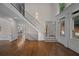Staircase and living room area featuring hardwood floors, large windows, and decorative molding at 8630 Moor Park Run, Duluth, GA 30097