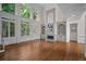Bright living room with fireplace, hardwood floors, built-in shelving, and large windows at 8630 Moor Park Run, Duluth, GA 30097