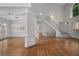 Open-concept living area featuring hardwood floors, a modern chandelier, and a staircase at 8630 Moor Park Run, Duluth, GA 30097