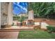 A brick outdoor kitchen including built-in barbecue grill, granite counters, and a brick fireplace at 8630 Moor Park Run, Duluth, GA 30097