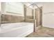 Bathroom featuring a tub and a glass-enclosed shower with tiled walls and floor at 9990 Blackfriars Rd, Douglasville, GA 30135