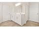 Bathroom view with double sinks, white cabinets, a large mirror, and two doors at 9990 Blackfriars Rd, Douglasville, GA 30135