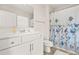 Bright bathroom featuring a white vanity and a shower with a floral curtain at 9990 Blackfriars Rd, Douglasville, GA 30135