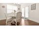 Bright breakfast nook features a white table set, hardwood floors, and a door to the outdoor area at 9990 Blackfriars Rd, Douglasville, GA 30135
