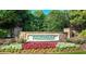 Community entrance sign for Tributary with stone pillars surrounded by colorful flowers and lush greenery at 9990 Blackfriars Rd, Douglasville, GA 30135