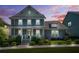 Charming two-story home with well-maintained lawn and landscape lighting at twilight at 9990 Blackfriars Rd, Douglasville, GA 30135