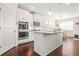 Modern kitchen features white cabinets, stainless appliances, an island, and an adjacent dining area at 9990 Blackfriars Rd, Douglasville, GA 30135