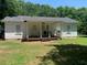 Rear exterior view of the house showcasing a covered porch and a well-kept lawn at 106 E Wade St, Oxford, GA 30054