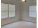 Bright bedroom with neutral walls, carpet, fan and two windows, making the space feel open and inviting at 106 E Wade St, Oxford, GA 30054