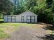 Exterior view of white barn with dark trim, with the natural surrounding landscape, creating a serene aesthetic at 106 E Wade St, Oxford, GA 30054