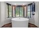 Bright bathroom featuring a modern soaking tub next to a window with wooden blinds and unique decor at 1180 Branch Water Ct, Dunwoody, GA 30338
