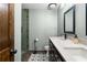 Bathroom with dual sinks, unique floor tiles, modern finishes, and a glass-enclosed shower at 1180 Branch Water Ct, Dunwoody, GA 30338