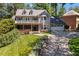 Two-story home with a front porch, balcony, manicured lawn, and driveway leading to a two-car garage at 1180 Branch Water Ct, Dunwoody, GA 30338