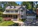 Charming two-story home with a welcoming porch and manicured lawn, nestled among mature trees at 1180 Branch Water Ct, Dunwoody, GA 30338