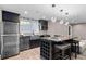 Modern kitchen with stainless steel appliances, island with seating, and stylish lighting at 1180 Branch Water Ct, Dunwoody, GA 30338