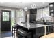 Modern kitchen featuring a black island with marble accents, bar stools, and stainless steel appliances at 1180 Branch Water Ct, Dunwoody, GA 30338