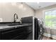 Laundry room with black marble counters and stainless steel washer/dryer at 1180 Branch Water Ct, Dunwoody, GA 30338