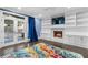 Spacious living room featuring a fireplace, built-in shelving, a colorful rug, and hardwood floors at 1180 Branch Water Ct, Dunwoody, GA 30338