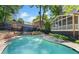 Backyard pool surrounded by lush landscaping, a screened porch, and a privacy fence at 1180 Branch Water Ct, Dunwoody, GA 30338