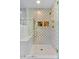 Elegant shower with unique gold-accented tile, a bench seat, and dual shower heads at 1180 Branch Water Ct, Dunwoody, GA 30338