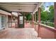 Exterior view of the back deck, showing a screened-in porch, wooden flooring and railing, and backyard trees at 2026 Mcdaniel Mill Sw Rd, Conyers, GA 30094