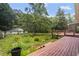 Exterior view of the back deck overlooking the lush green backyard with mature trees at 2026 Mcdaniel Mill Sw Rd, Conyers, GA 30094