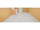A view of the unfinished basement featuring paneled walls, carpet, and a white entry door at 2026 Mcdaniel Mill Sw Rd, Conyers, GA 30094