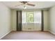 Bedroom with carpet flooring, ceiling fan, and large window with tree views at 2026 Mcdaniel Mill Sw Rd, Conyers, GA 30094