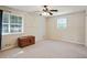 Spacious bedroom with neutral carpet, two windows, and a classic wood dresser at 2026 Mcdaniel Mill Sw Rd, Conyers, GA 30094