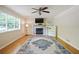 Bright living room features a fireplace, ceiling fan, and a large window for ample natural light at 2026 Mcdaniel Mill Sw Rd, Conyers, GA 30094