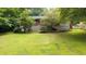 View of the expansive backyard, showcasing the lawn, trees, and the rear of the house at 2100 Shady Ln, Tucker, GA 30084