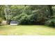 Spacious backyard featuring a shed, lawn, and mature trees, offering privacy at 2100 Shady Ln, Tucker, GA 30084