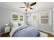 Bright bedroom with ceiling fan, hardwood floors, and natural light from two windows at 2100 Shady Ln, Tucker, GA 30084