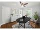 This bedroom is staged as an office and features hardwood floors and a ceiling fan at 2100 Shady Ln, Tucker, GA 30084