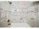 Detailed view of a new shower and tub with marble tiling and built-in storage shelves at 2100 Shady Ln, Tucker, GA 30084