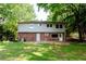 Spacious backyard featuring lush lawn, mature trees, and a brick home exterior with a patio at 4339 Sasanqua Ct, Tucker, GA 30084