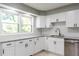 Updated kitchen with white cabinets, granite countertops, stainless steel appliances, and a window view at 4339 Sasanqua Ct, Tucker, GA 30084