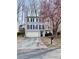 Two-story home with a two-car garage, manicured lawn, and tree with vibrant pink blossoms at 5105 N Bridges Dr, Alpharetta, GA 30022