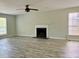 Open living room with modern fireplace, ceiling fan, and large windows at 5105 N Bridges Dr, Alpharetta, GA 30022