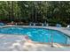 Community pool surrounded by mature trees featuring lounge chairs for relaxation and enjoyment by residents at 1416 Oakridge Cir, Decatur, GA 30033