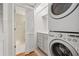 Convenient laundry area features a stacked washer and dryer, storage cabinets, and access to the Primary bath at 1416 Oakridge Cir, Decatur, GA 30033
