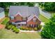 Stunning aerial view of a brick home with a manicured lawn and a lush green surrounding at 1657 Hampton Woods Way, Lawrenceville, GA 30043