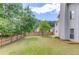 Fenced backyard featuring a lush, green lawn and mature trees at 1657 Hampton Woods Way, Lawrenceville, GA 30043