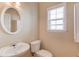 Cozy powder room with pedestal sink, oval mirror and natural light at 1657 Hampton Woods Way, Lawrenceville, GA 30043