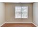 A room with hardwood floors and neutral walls showcasing a large window with blinds at 1657 Hampton Woods Way, Lawrenceville, GA 30043
