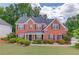 Charming two-story brick home with a well-manicured lawn and lush landscaping at 1657 Hampton Woods Way, Lawrenceville, GA 30043